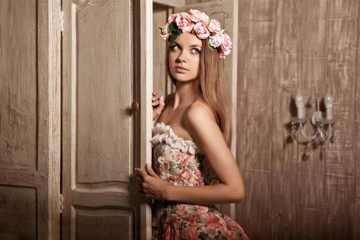 a young lady is dressed in elegant vintage floral dress with flower head wreath