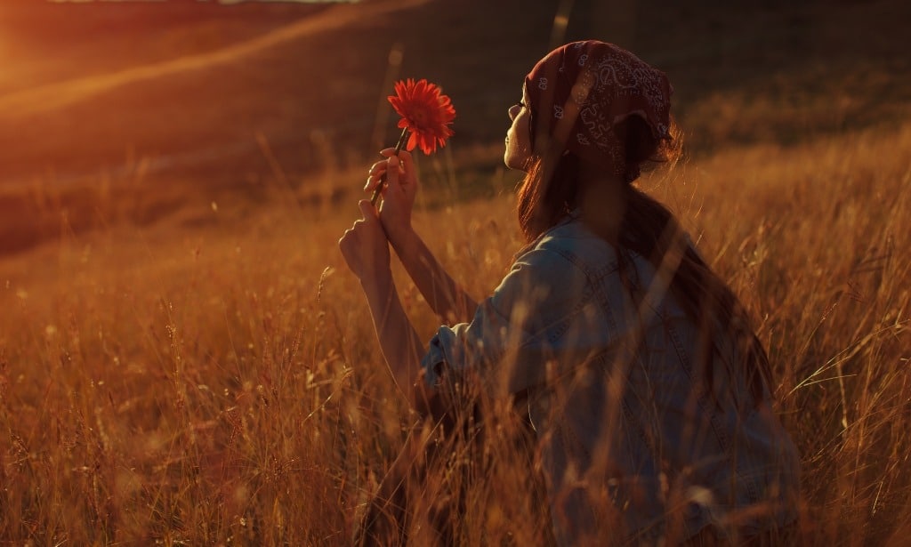 Young woman hold flower and enjoy the sunset in nature.