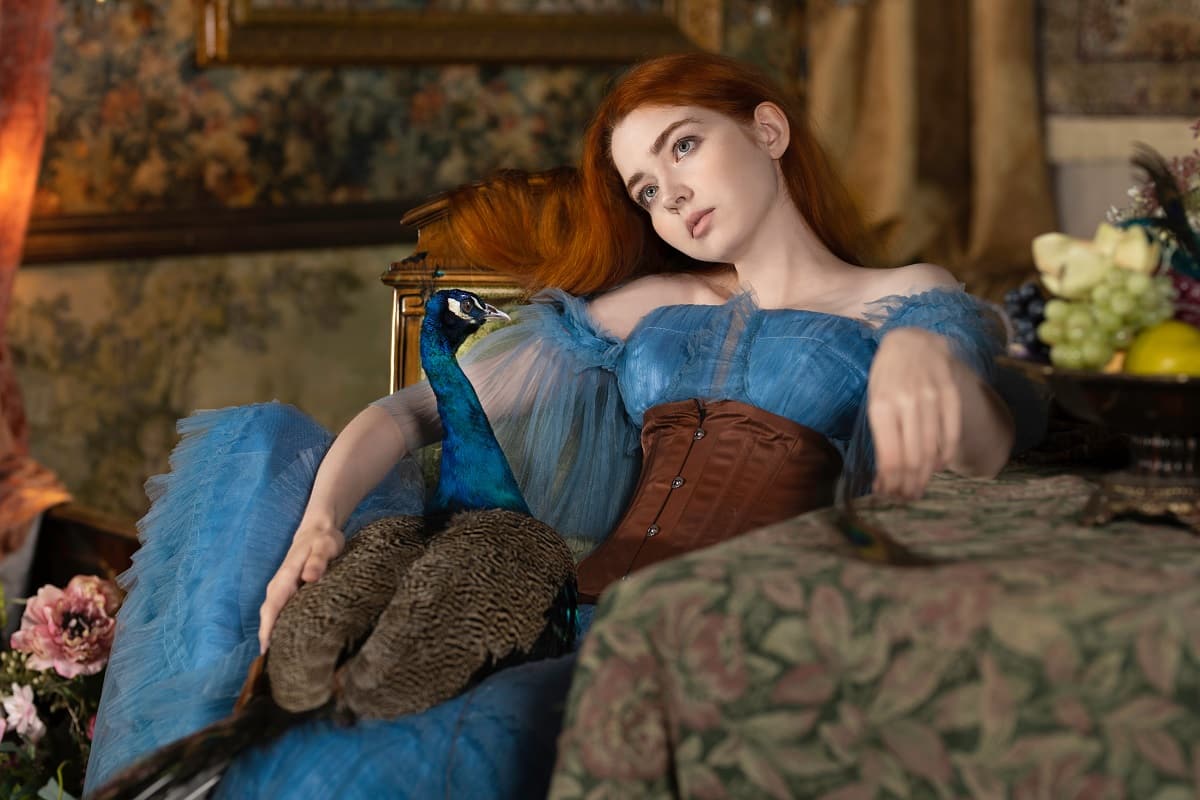 a red-haired young lady with a peacock is relaxing in a vintage room