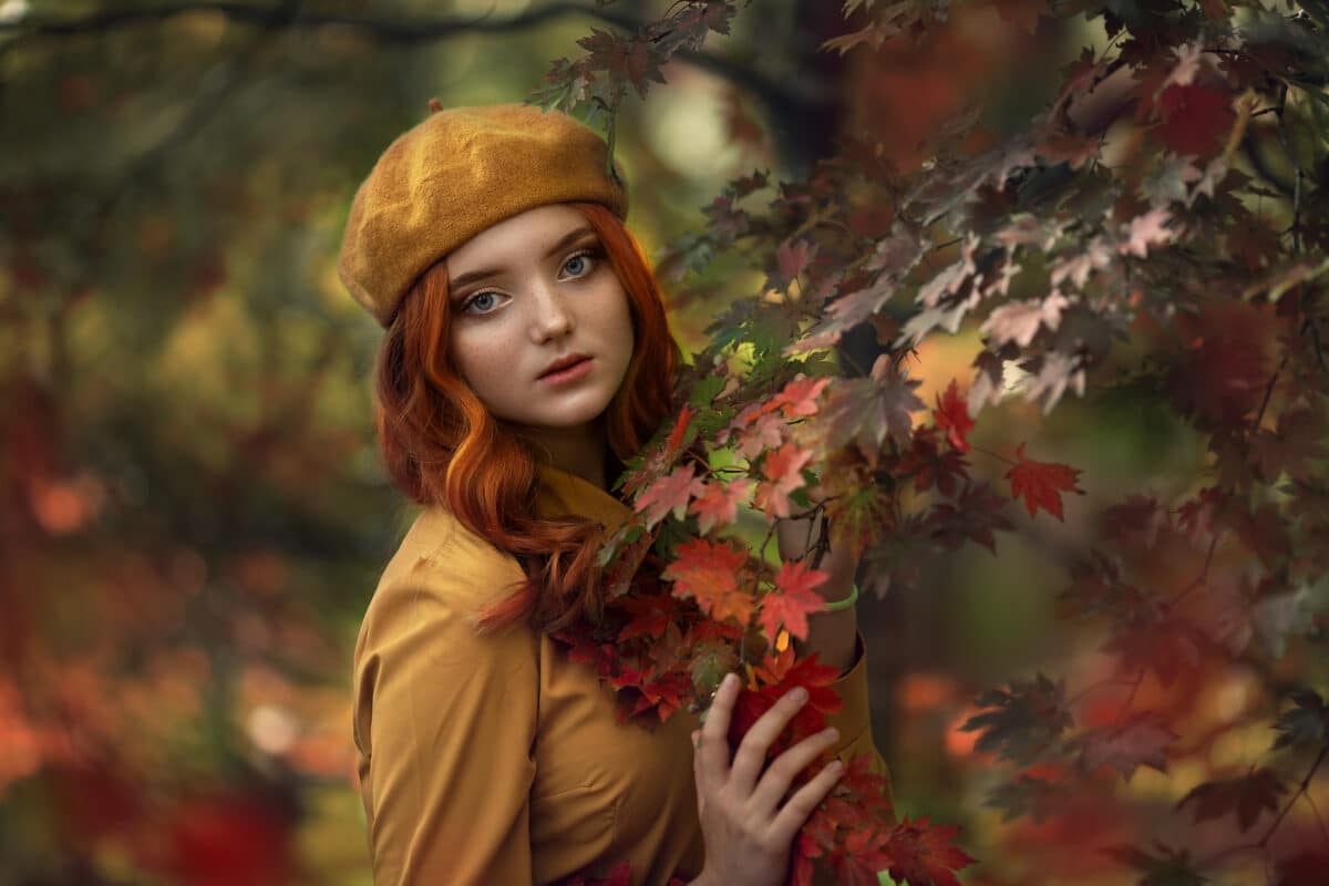 a red-haired young woman in the autumn forest