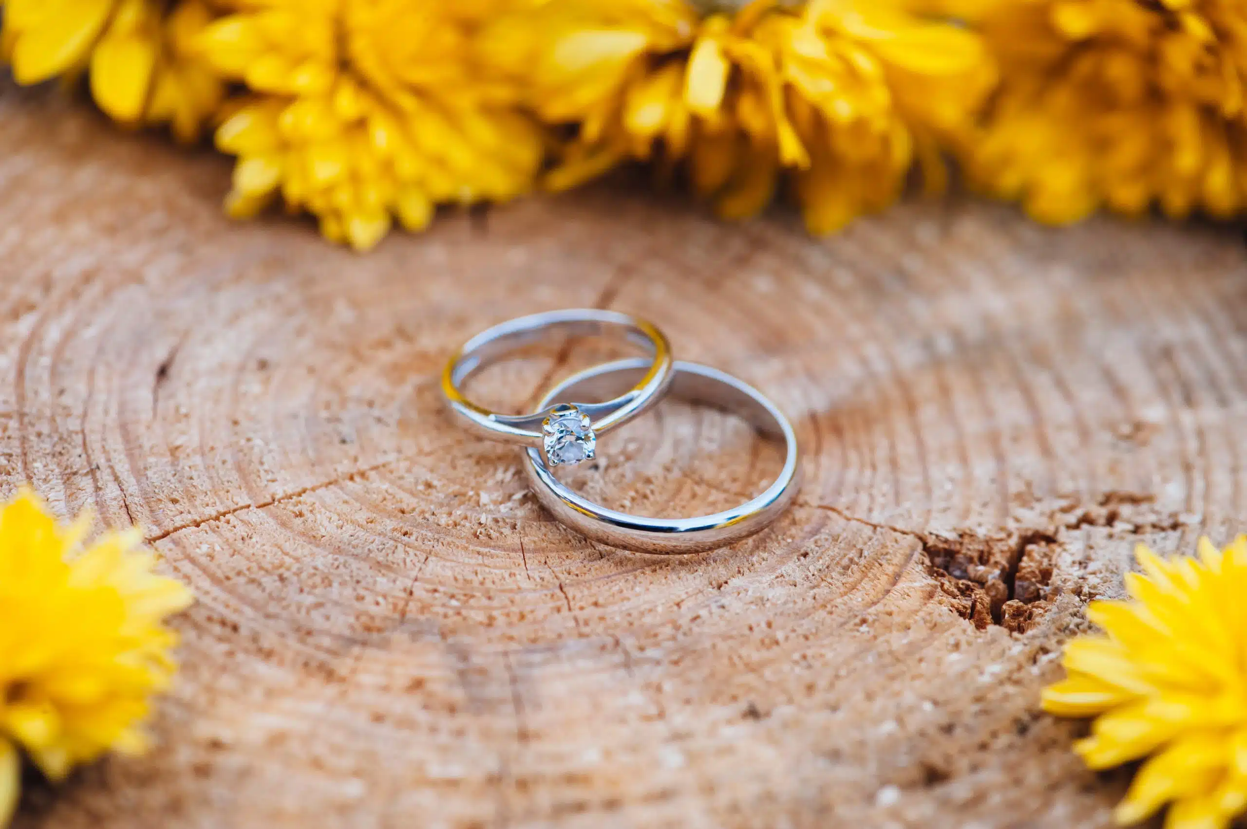 Beautiful two wedding rings, one with a diamond, on a wooden table