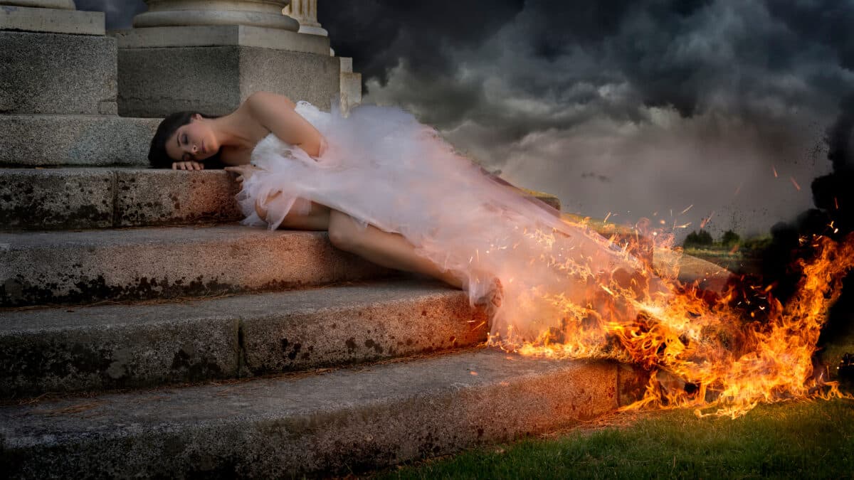 woman in white dress burning lying on the stairs of a temple