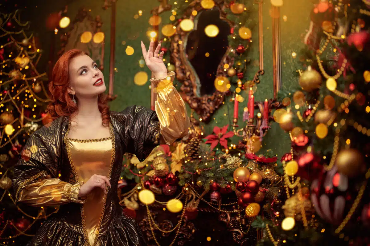 redhaired lady standing in front of a christmas tree