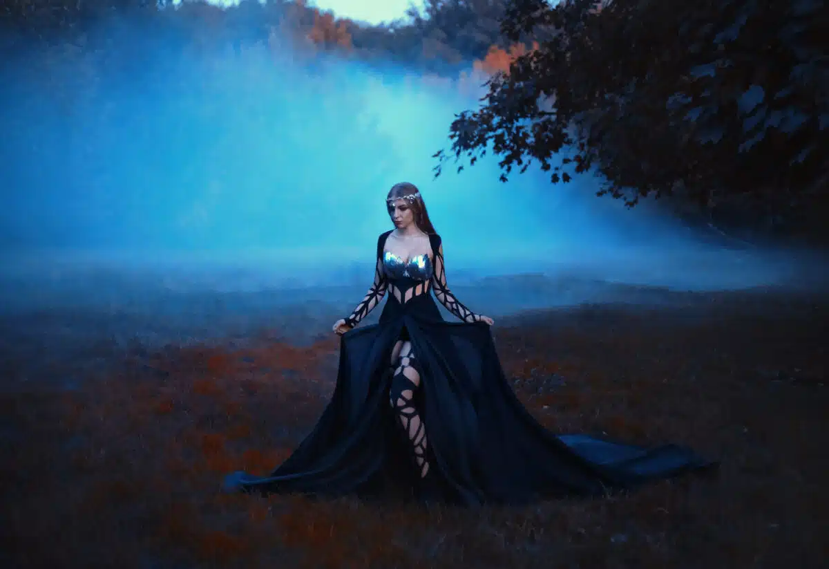 The dark queen of elves walks in a misty forest. A creative imag