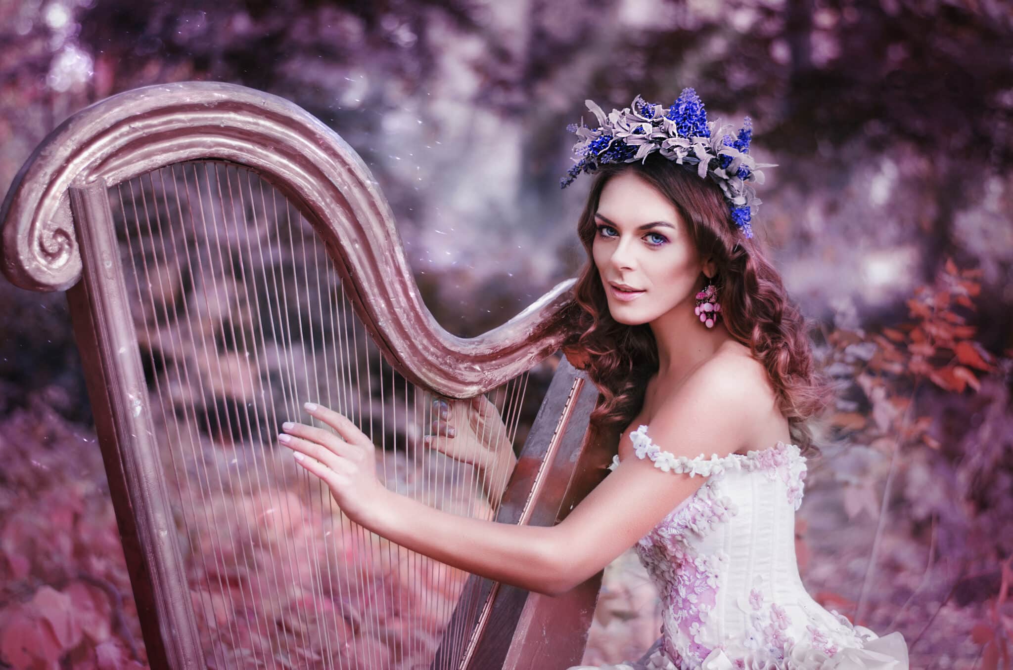beautiful mystical woman with a flower wreath on her head playing the harp in the woods