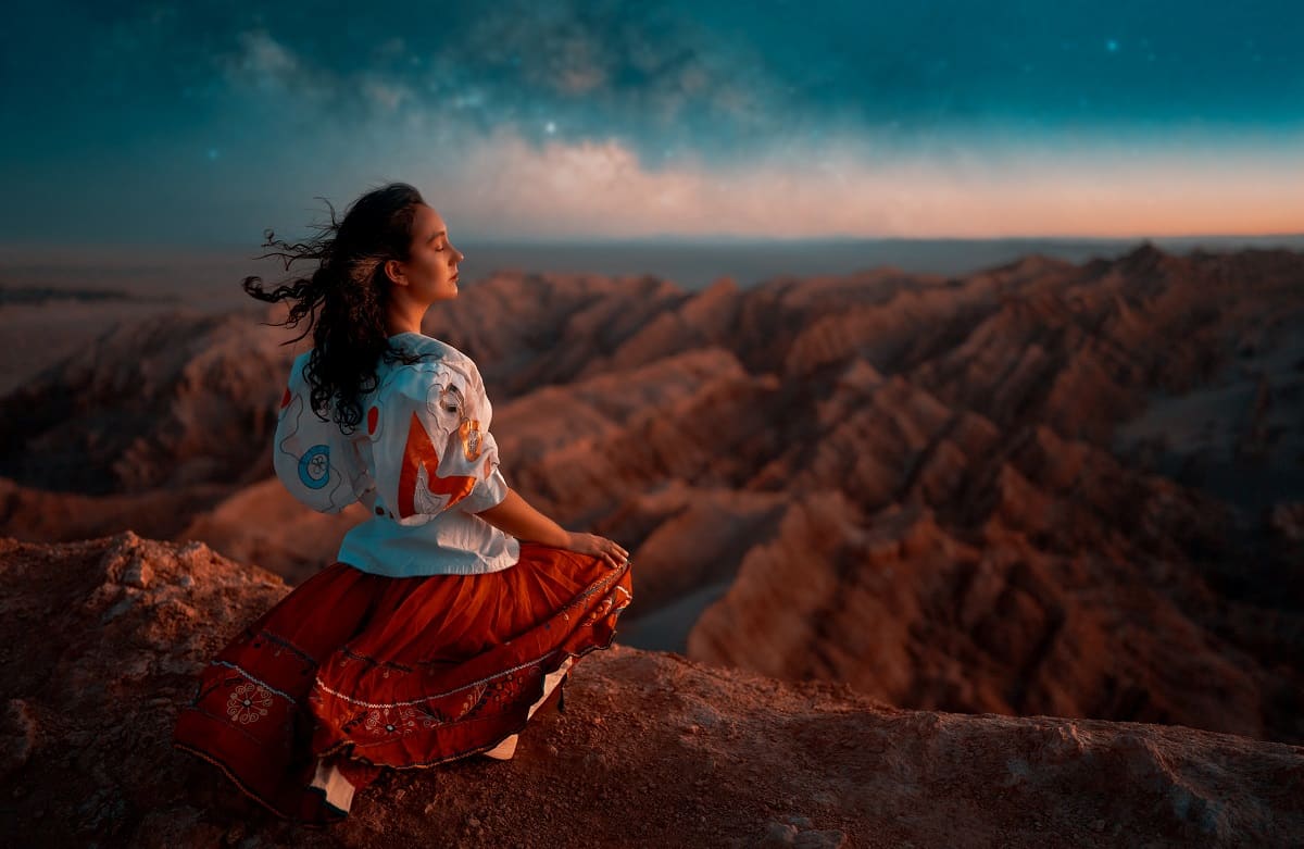 woman sitting and meditating in the warm breeze of the desert