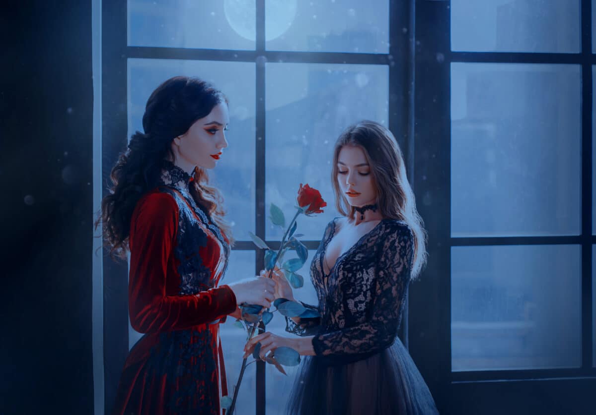 brunette vampire woman gives red rose cute medieval beauty blonde girl princess. 