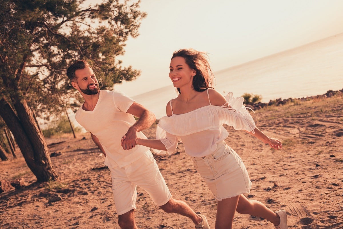 Lovely couple good mood enjoy time together run near ocean lake romantic bonding sunny weather outdoors