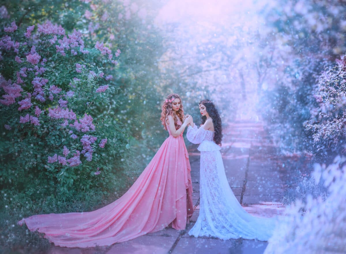 concept of change season winter and spring meet. Stylish luxury vintage design gown long train. Two women model blonde and brunette hugging. Idea inspiration family photoshoot. Fabulous snow nature