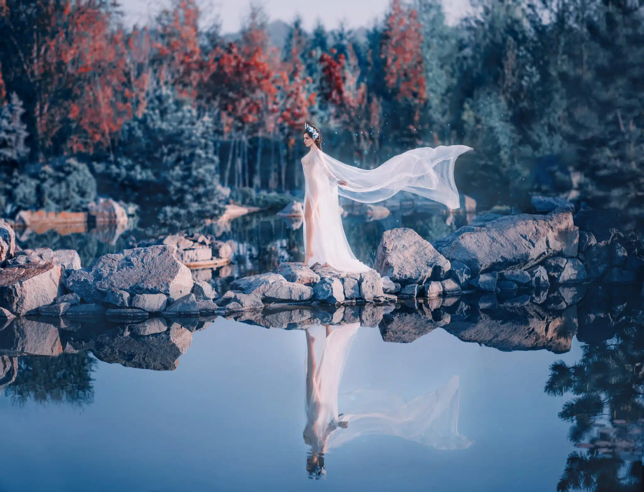 River nymph walks against the backdrop of mountains and wild forests, her reflection in the water