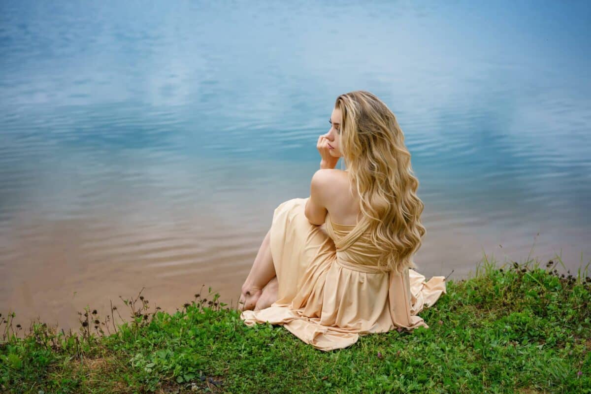 enchanting lady sitting by the river 