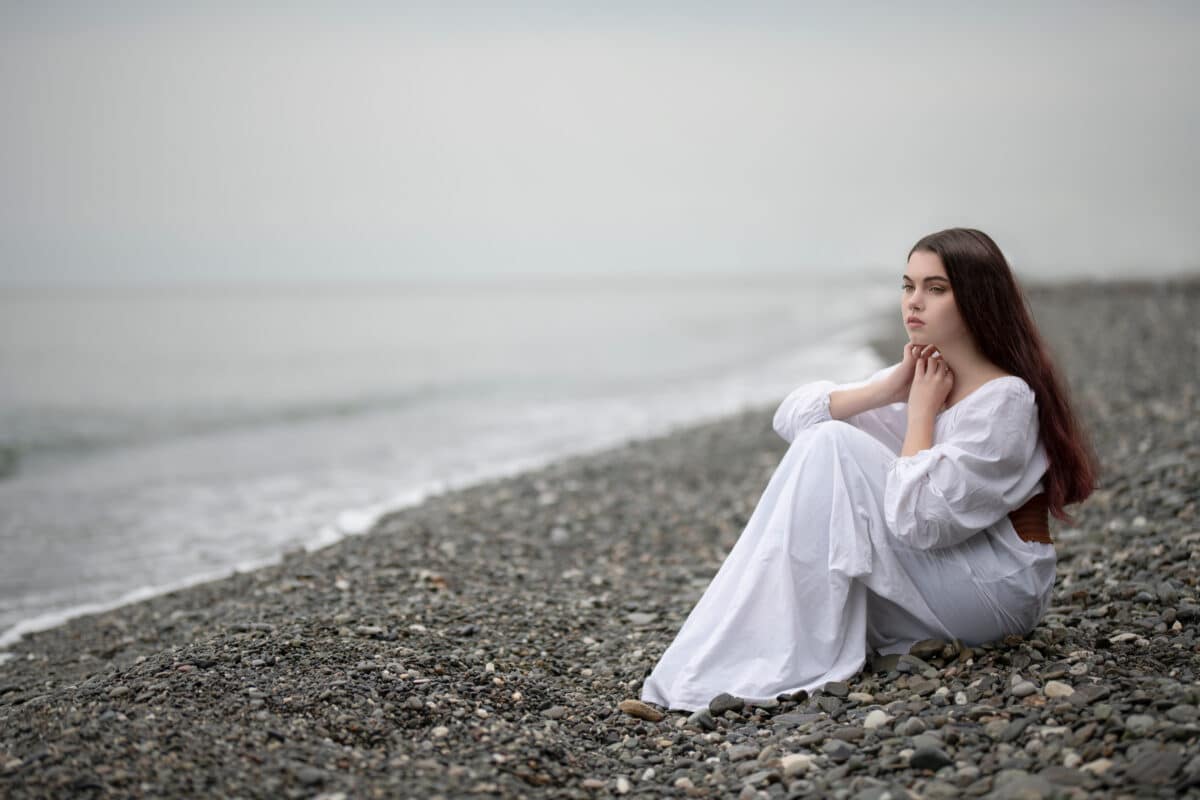 a girl dressed white sitting on the Black Sea coast