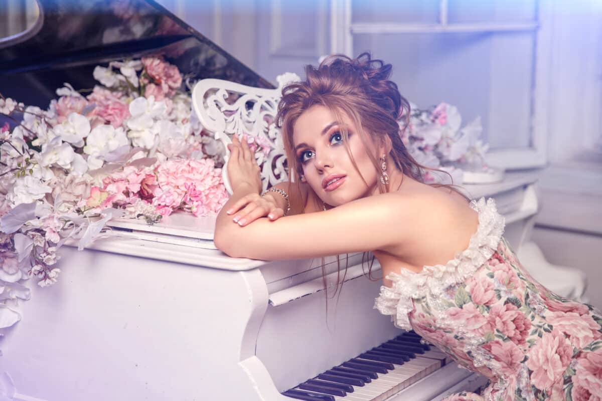 vintage style beautiful woman resting head on the piano