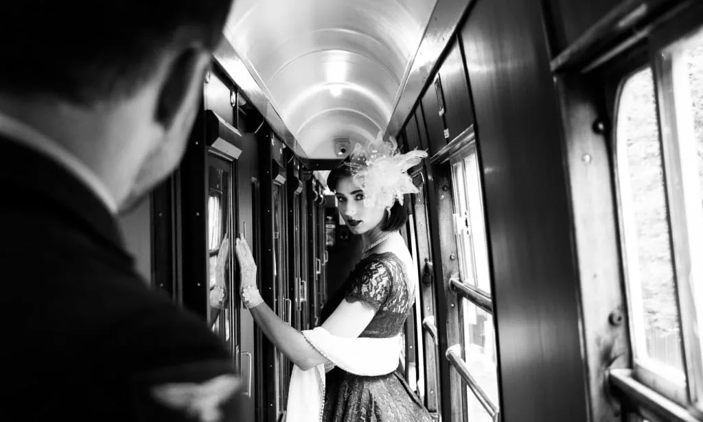 Vintage woman standing in corridor on train looking at her man.