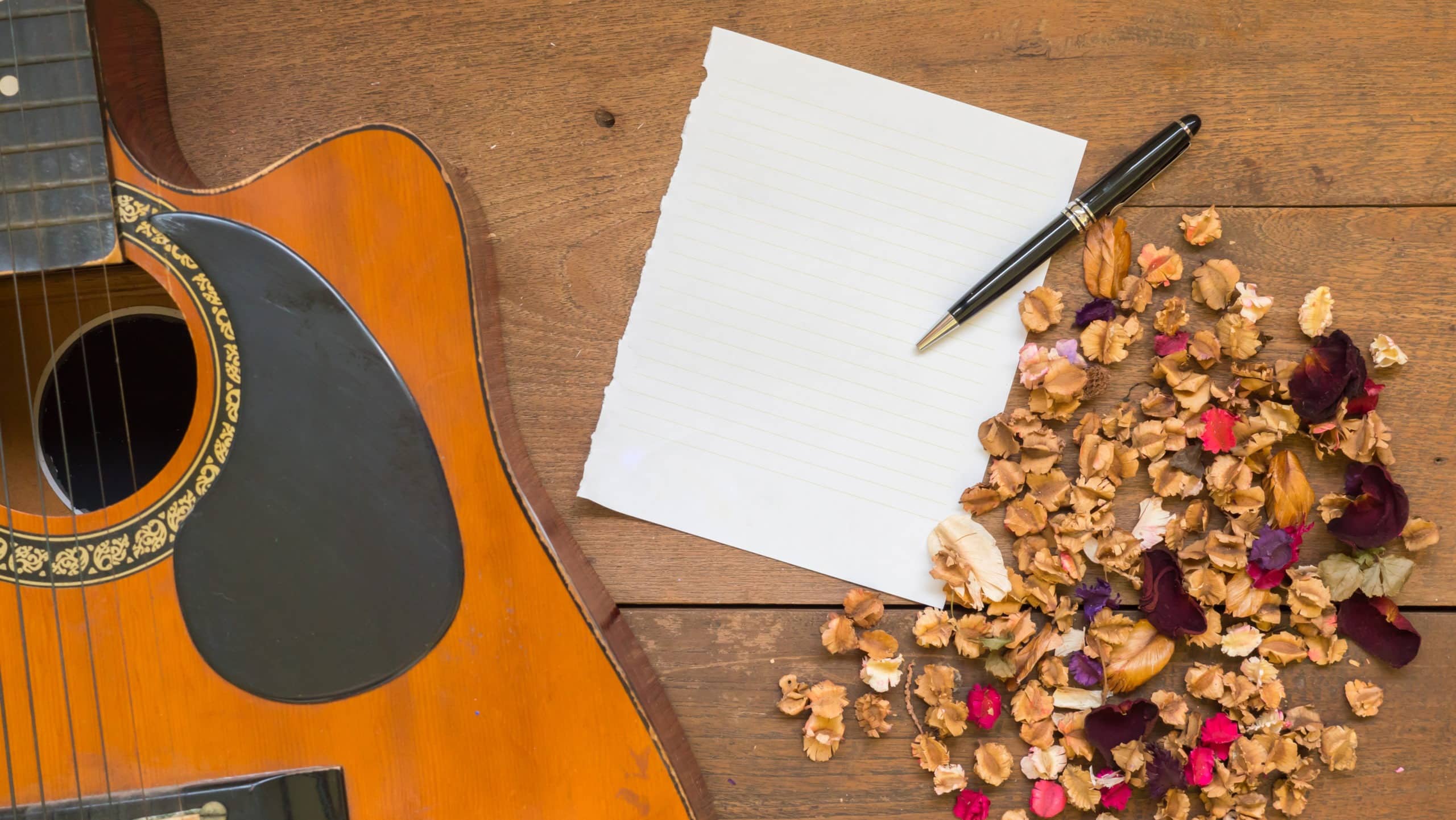 Workspace with blank paper ,acoustic guitar and dried flowers
