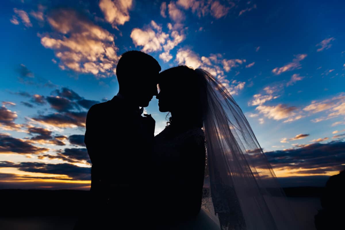 silhouette of newlyweds and the beautiful night sky after sunset behind them