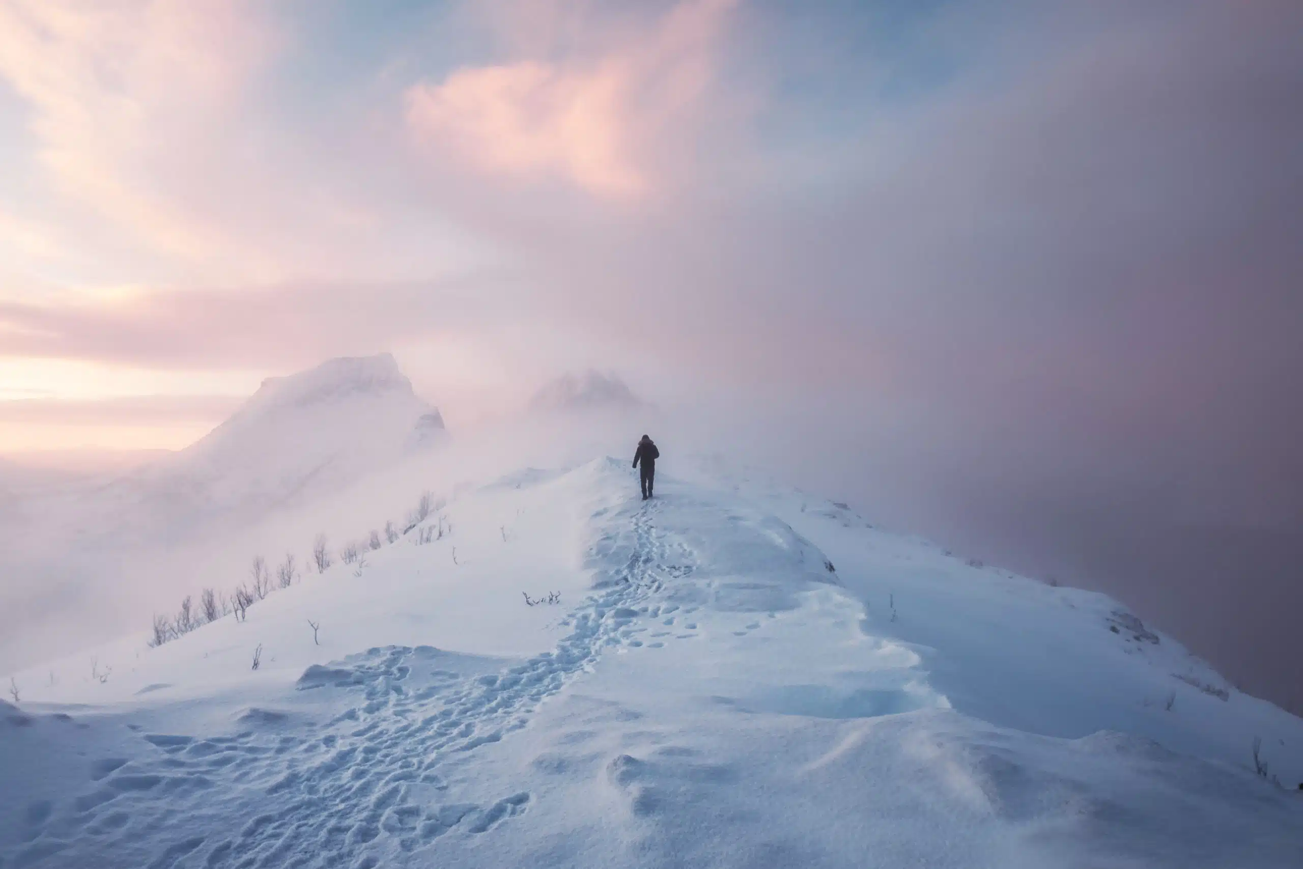 Man mountaineer walking alone with footprint on snowy mountain.