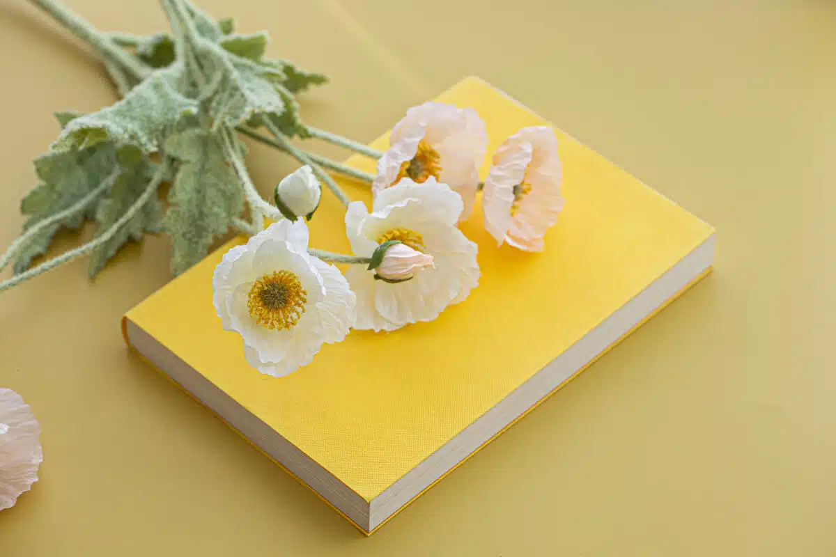 Yellow flowers on top of a book and thank you note