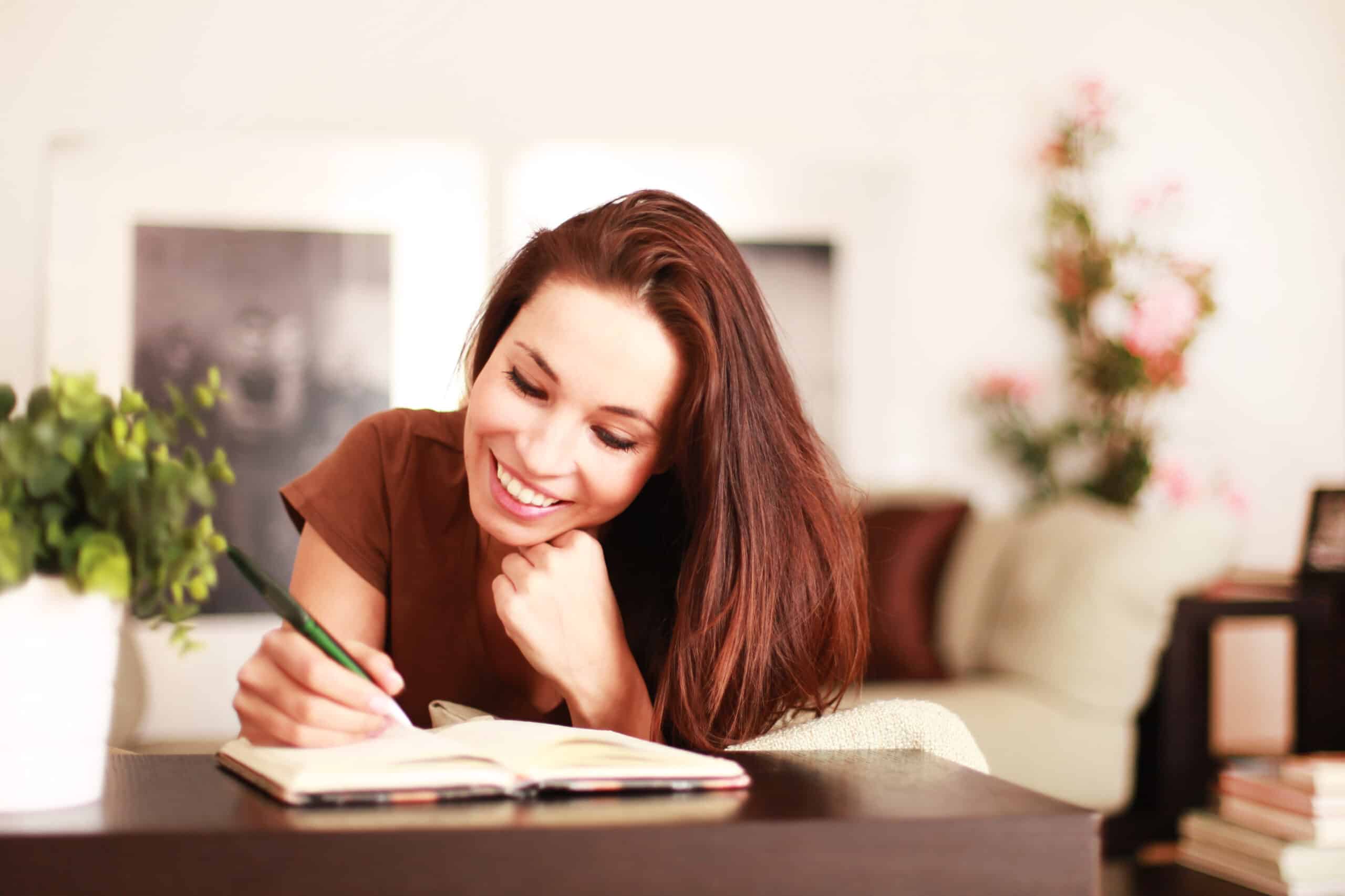 redhead lady writing on table at home smiling