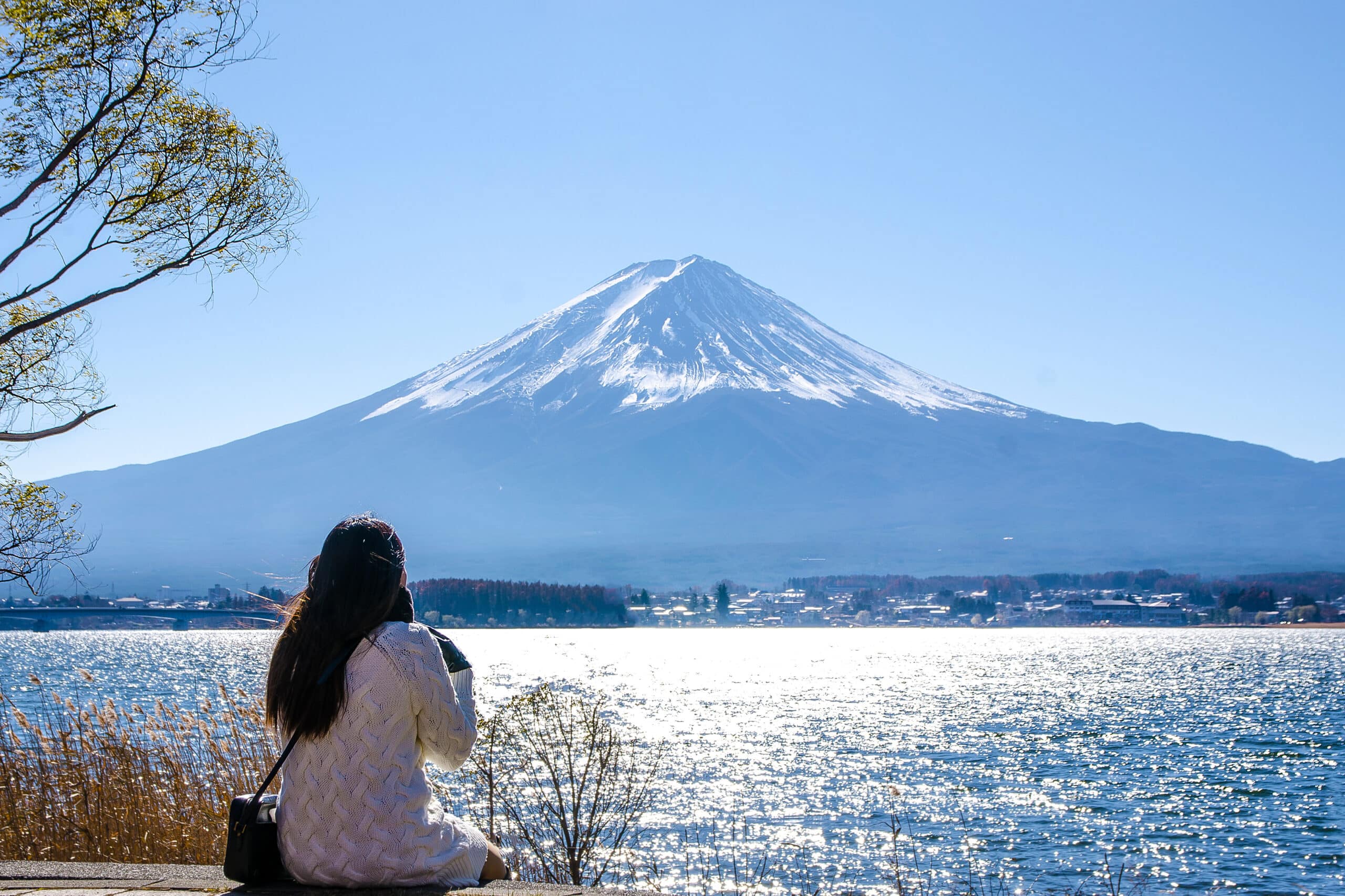 Woman sitting on the ground at kawaguchiko lake, Japan. 