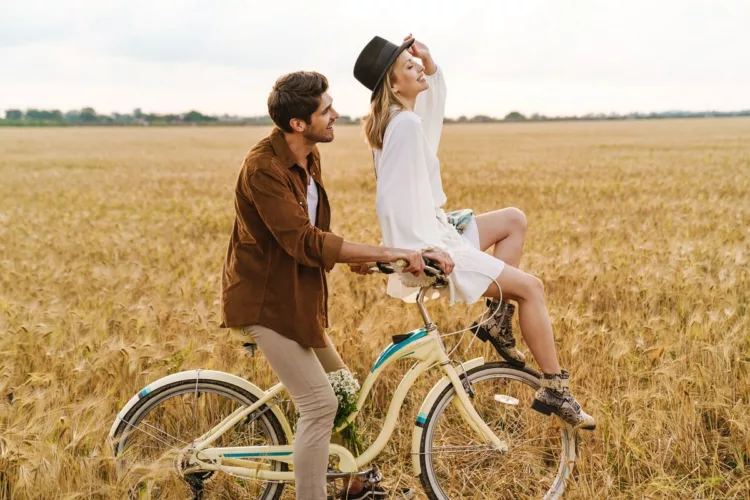 young couple smiling and riding bicycle together