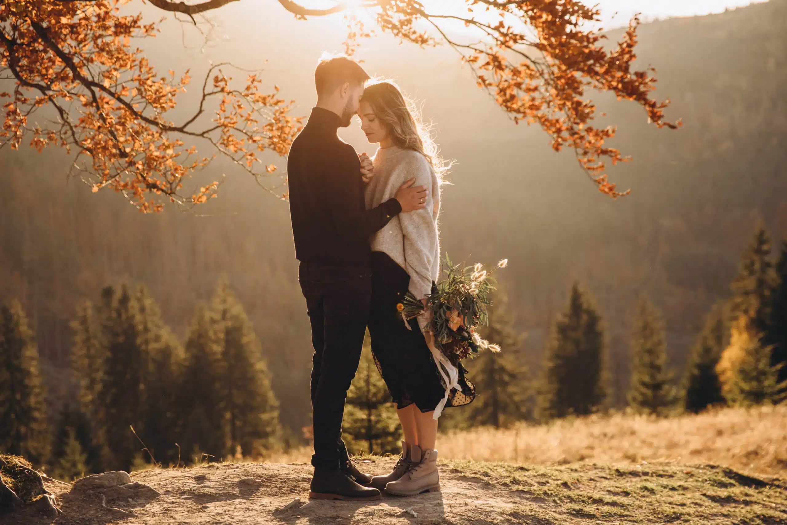 Stylish young couple in the autumn mountains. A guy and a girl s
