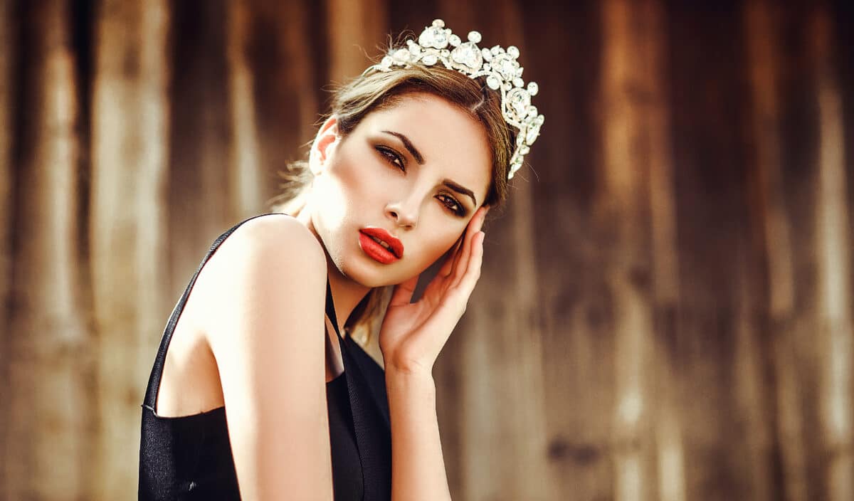 Beautiful girl model blonde summer outdoors in the crown. Red lips, manicure, smoky eyes. photo art, soft focus.