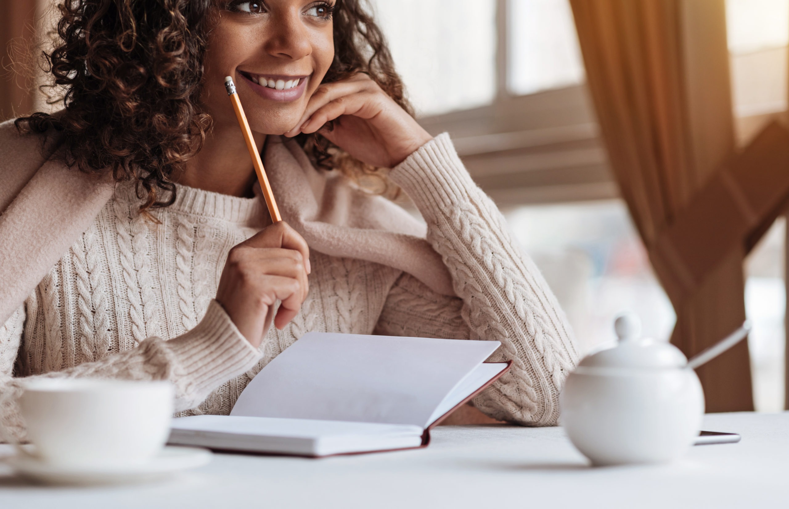 Attractive African American woman writing at the café