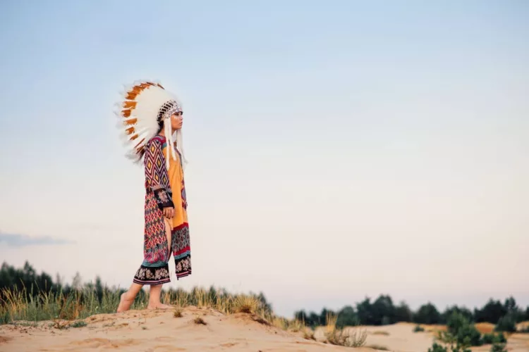 female American native indian standing on top of a hill