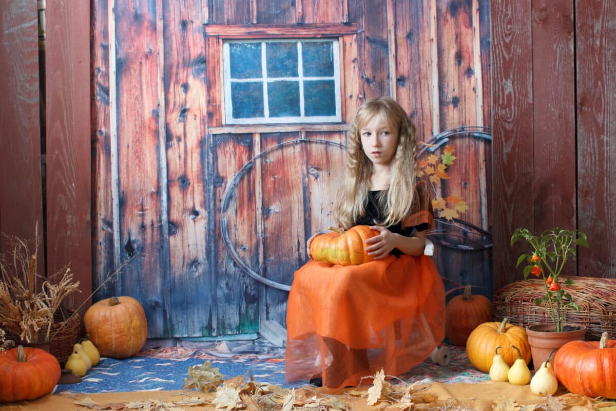 fairytale girl sitting on a stool with a pumpkin on her lap