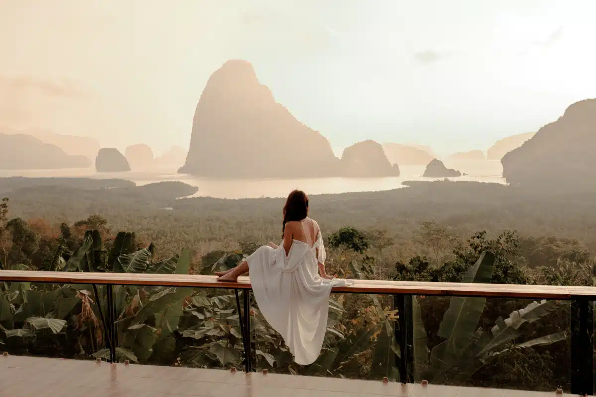 Woman with the white dress sit and see the mountain in early mor.