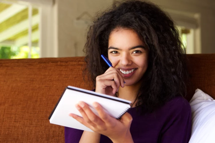 Attractive young woman writing in a notebook.