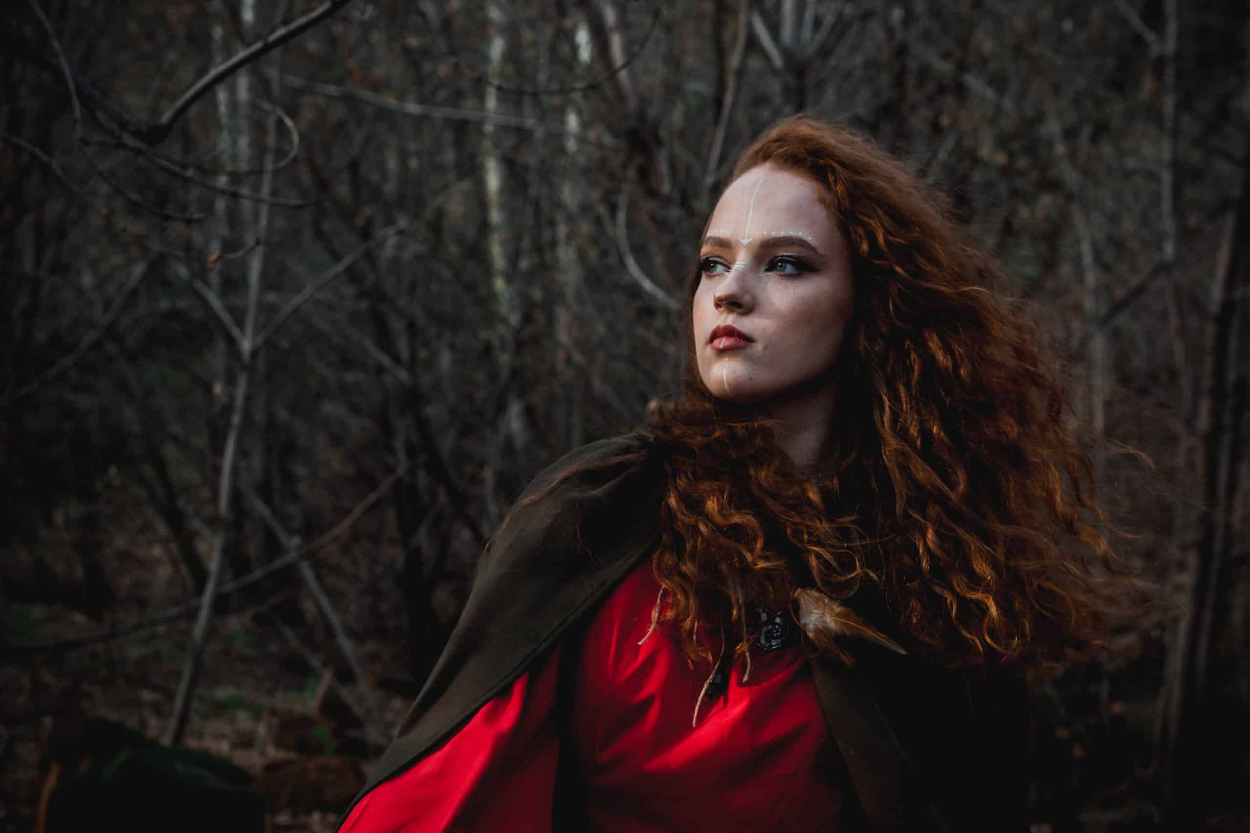Red-haired woman in a red dress in a historical Celtic dress.