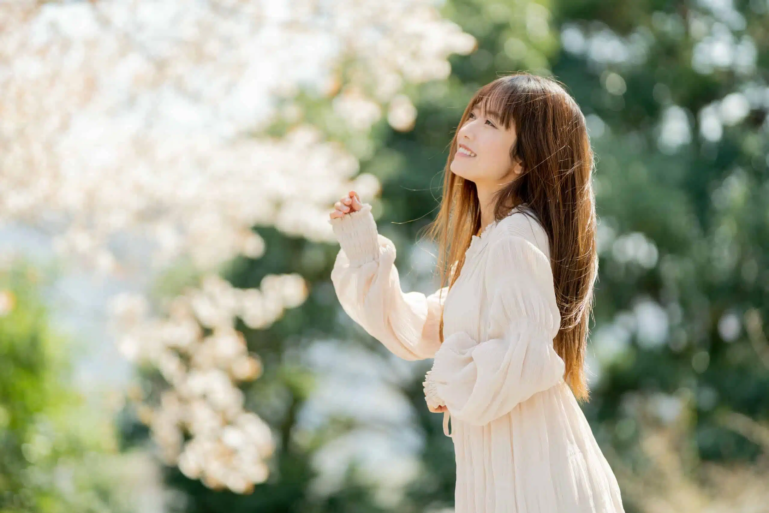 young asian woman enjoys the blooming trees