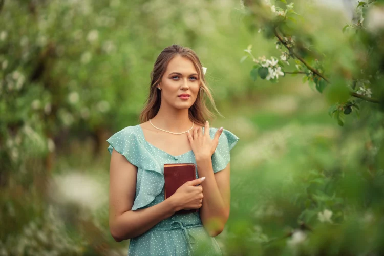 beautiful young woman in a romantic dress reads a book