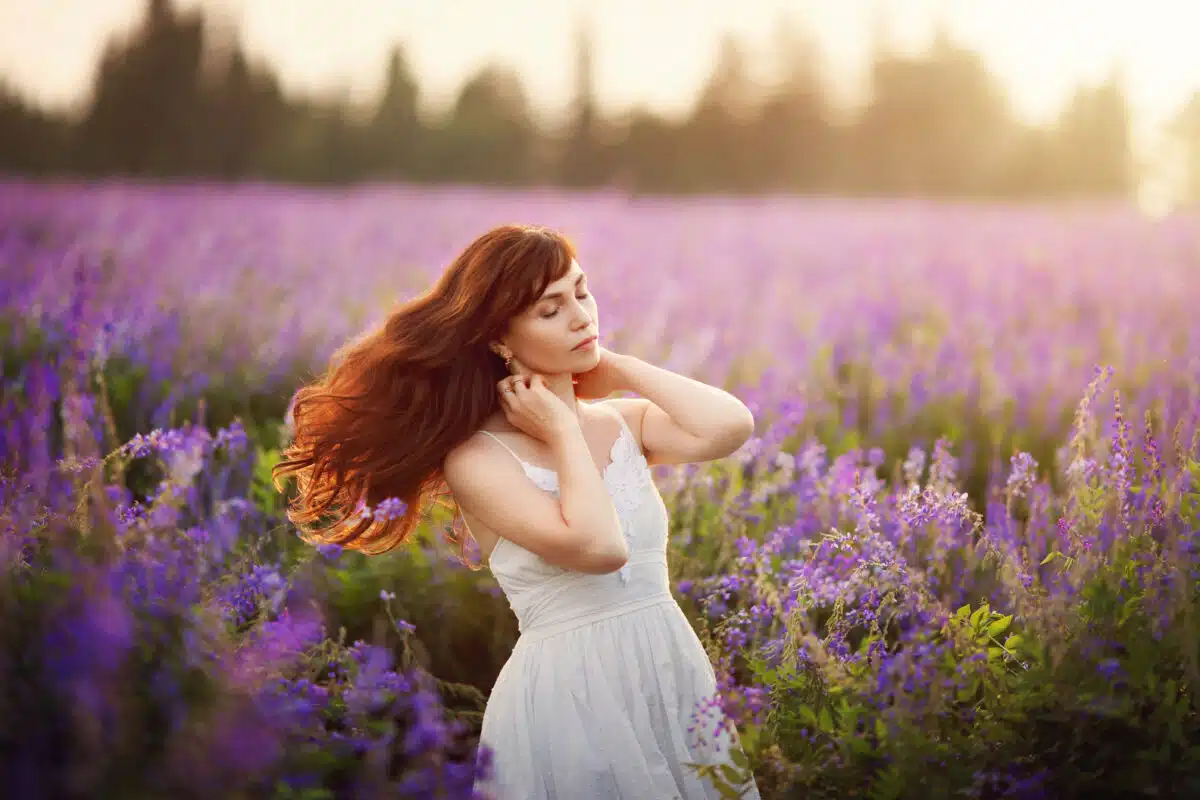 a beautiful lady in a field of purple wild flowers
