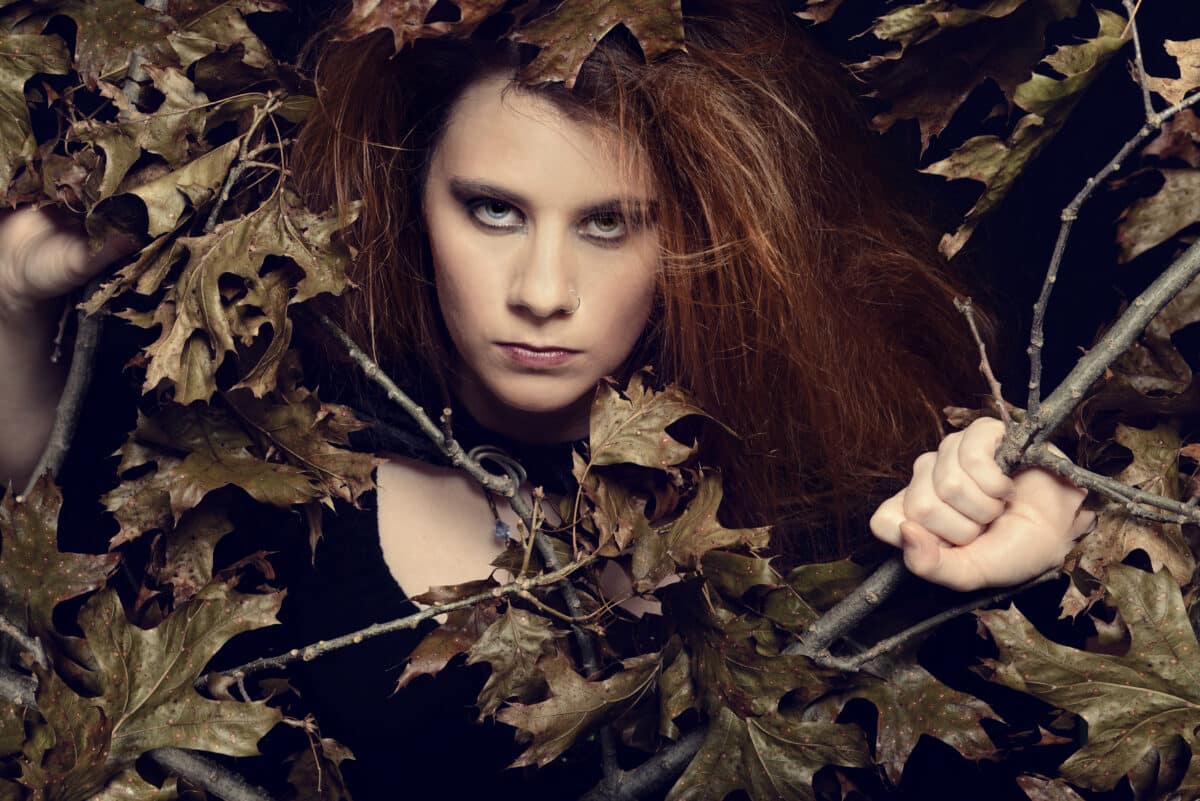 angry woman looking through tree branches