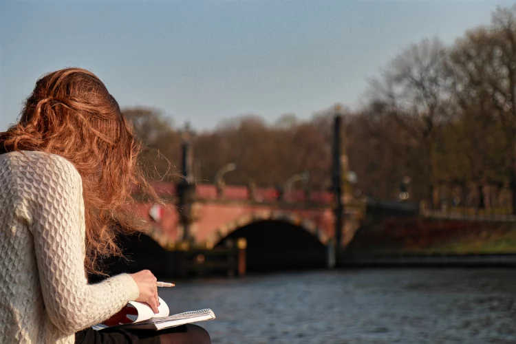  Woman reading a book by the river