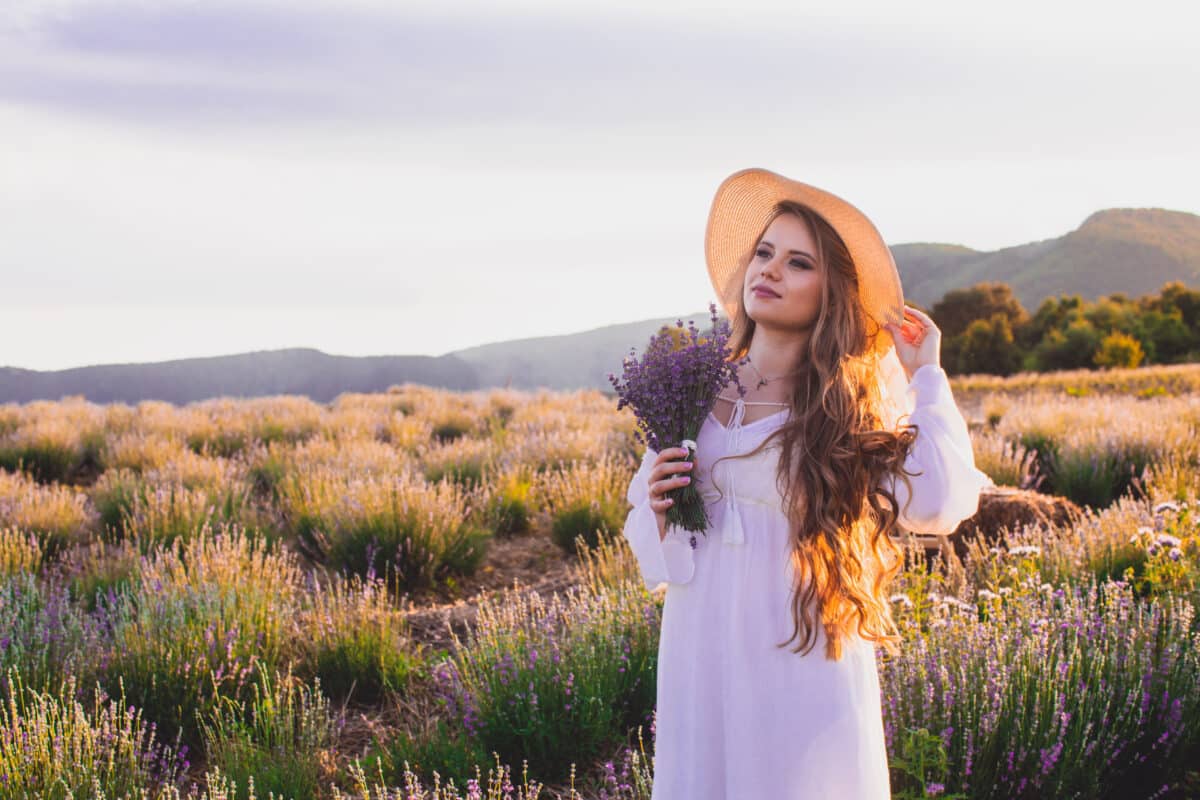 woman is standing in the lavender field at sunset