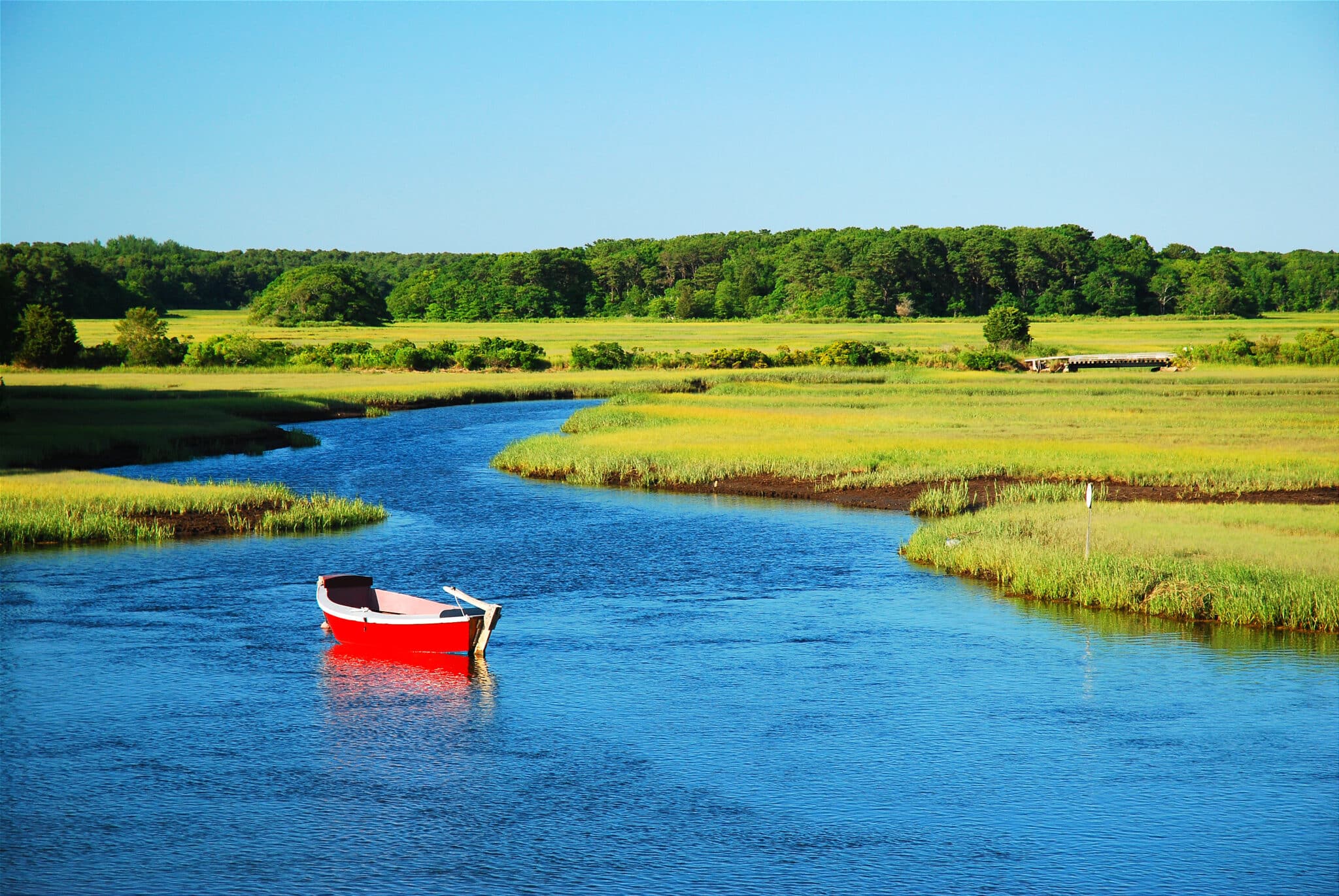 a red canoe in a calm marsh