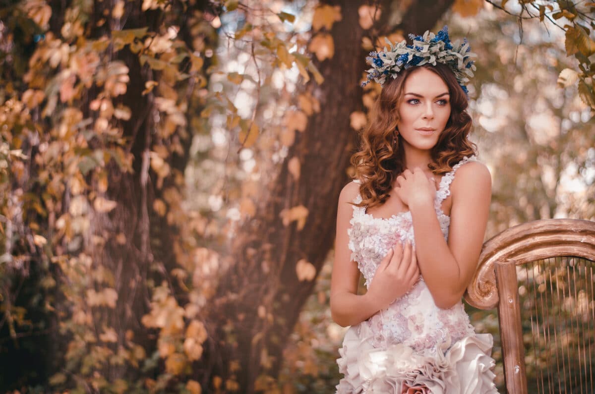 Beautiful brown-haired woman standing in a flower wreath on her hair