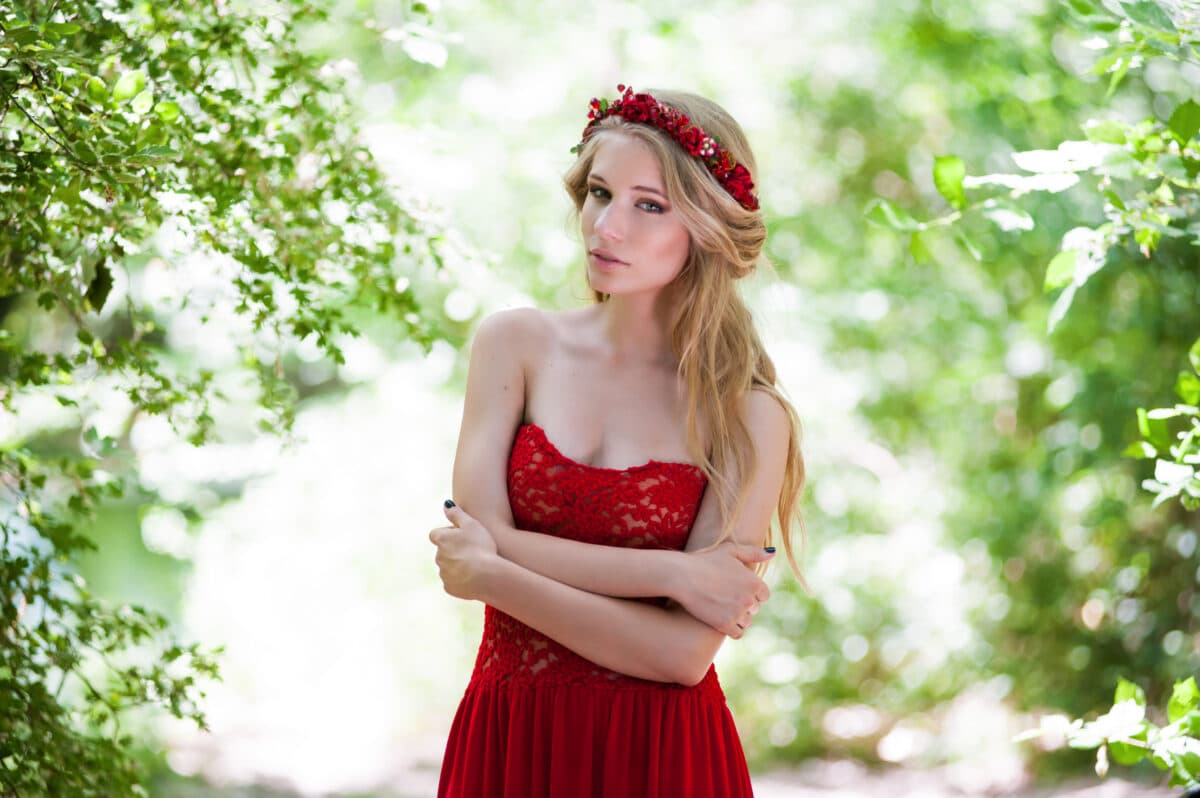 young beautiful blonde girl in a red dress in the summer