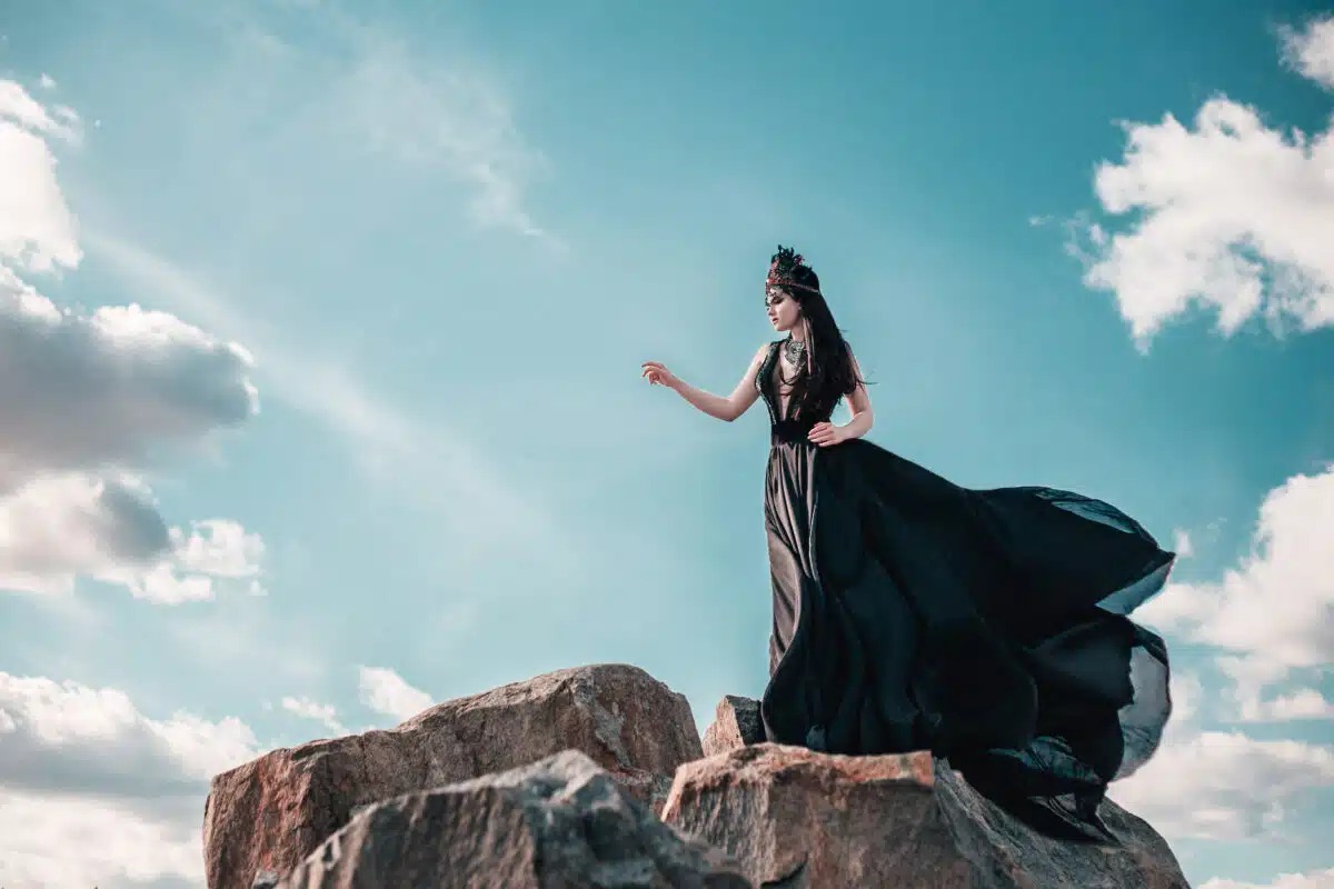 dark goth wild princess standing on the canyon against the blue sky