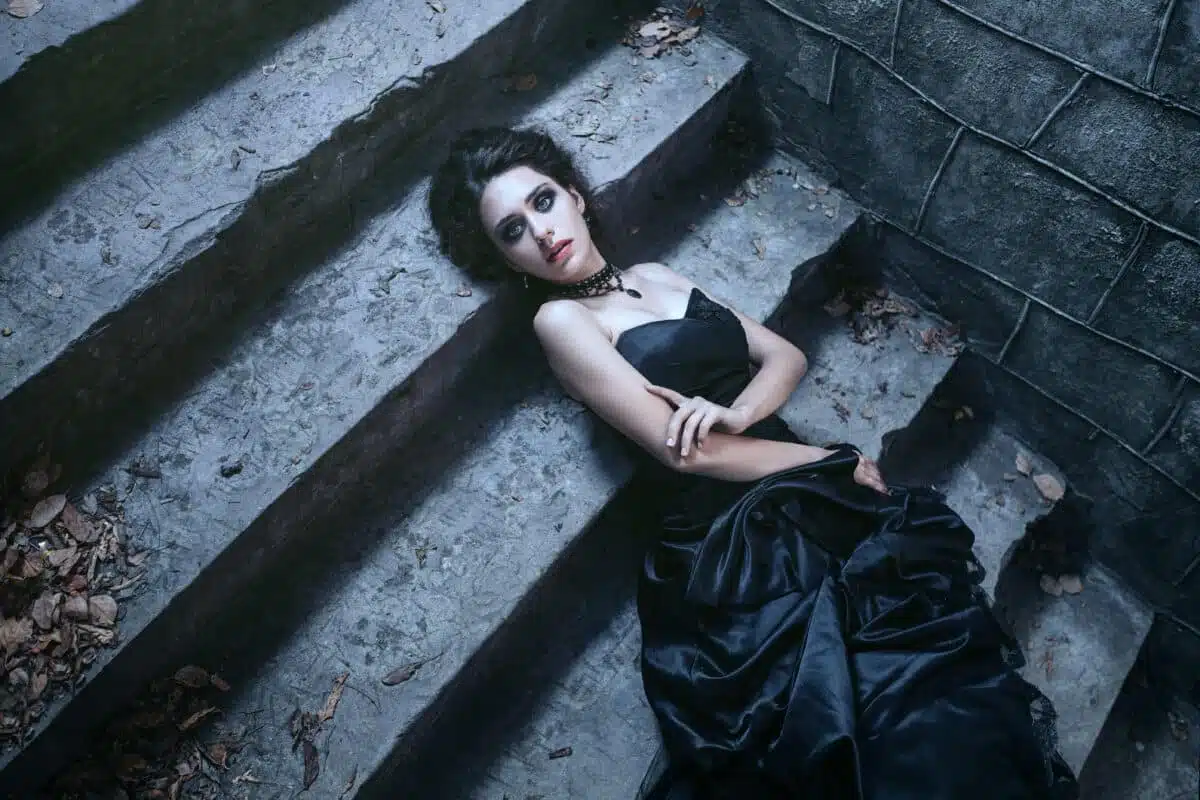 dark brunette lady lying on the stairs of a castle