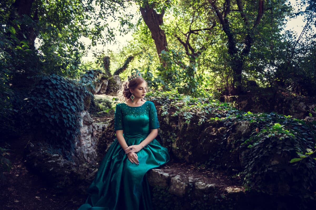 Young woman wearing a green dress explores a magical forest