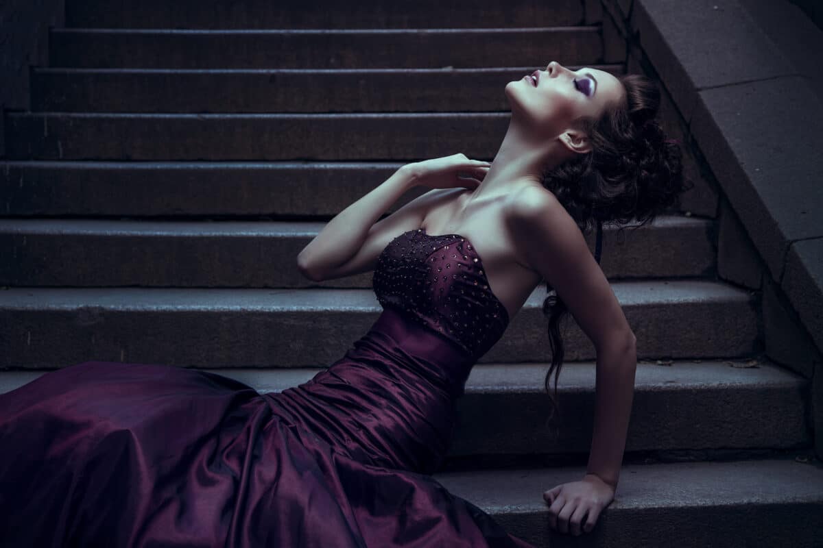  a beautiful woman in a violet dress on a flight of stairs