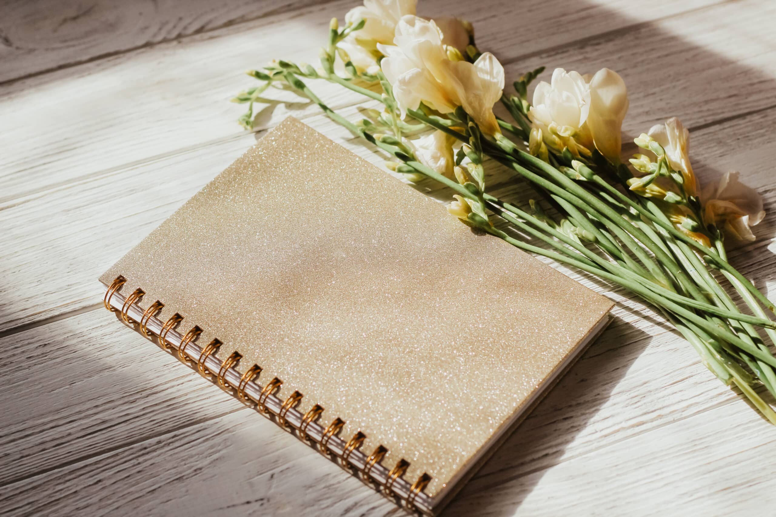 Diary notebook on the background of flowers and wooden figured boards
