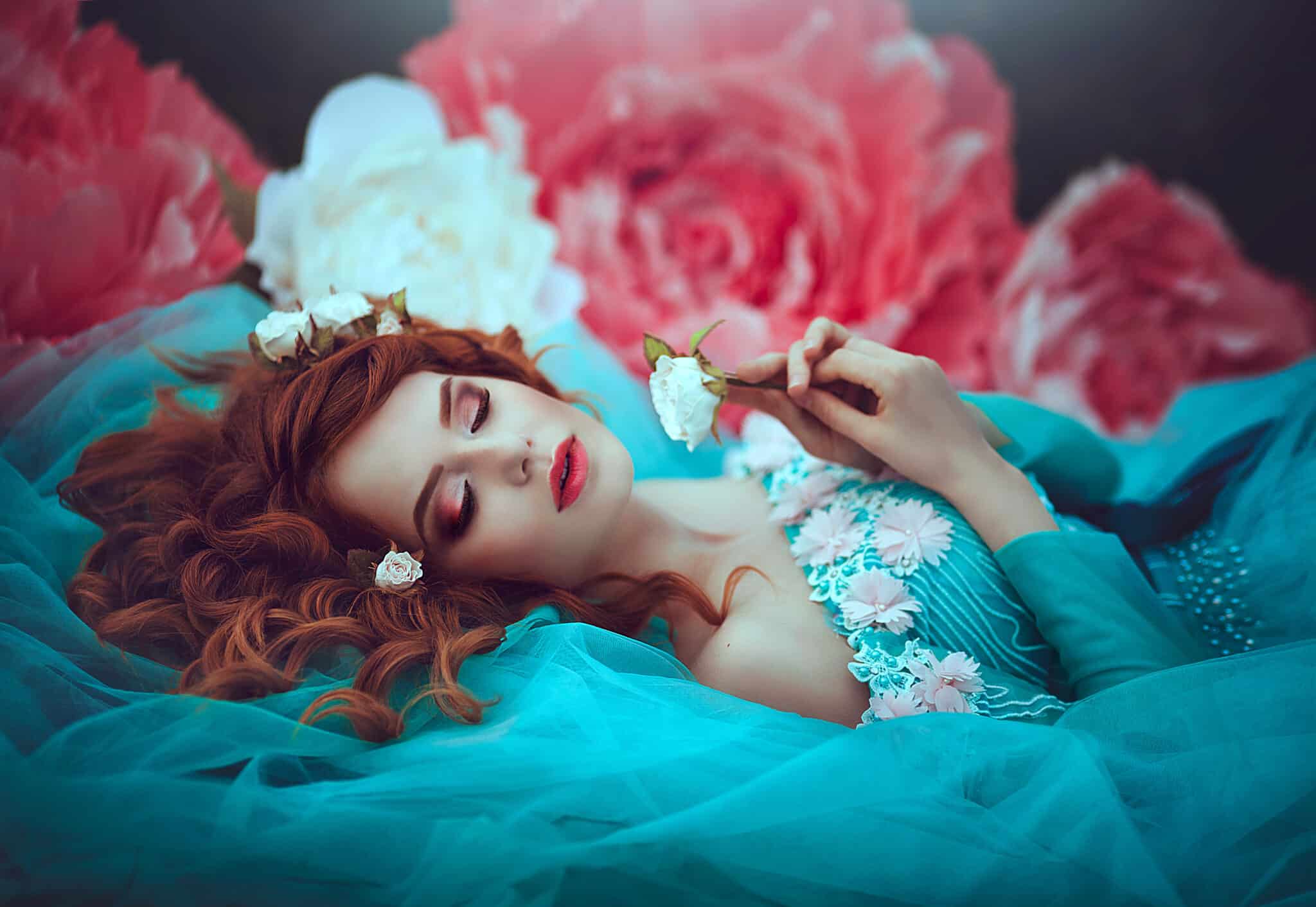 A beautiful sensual girl with red hair in a fairy blue lavish 