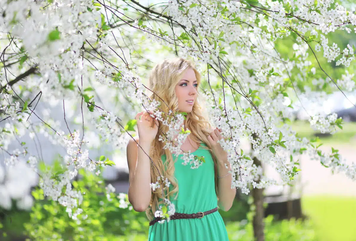 Beautiful blonde woman in a spring garden looking to the side