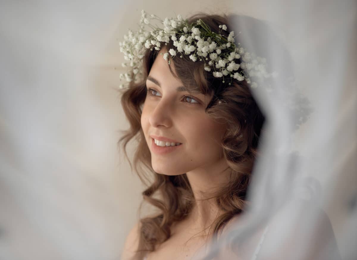 smiling young lady with a white flower wreath on her head